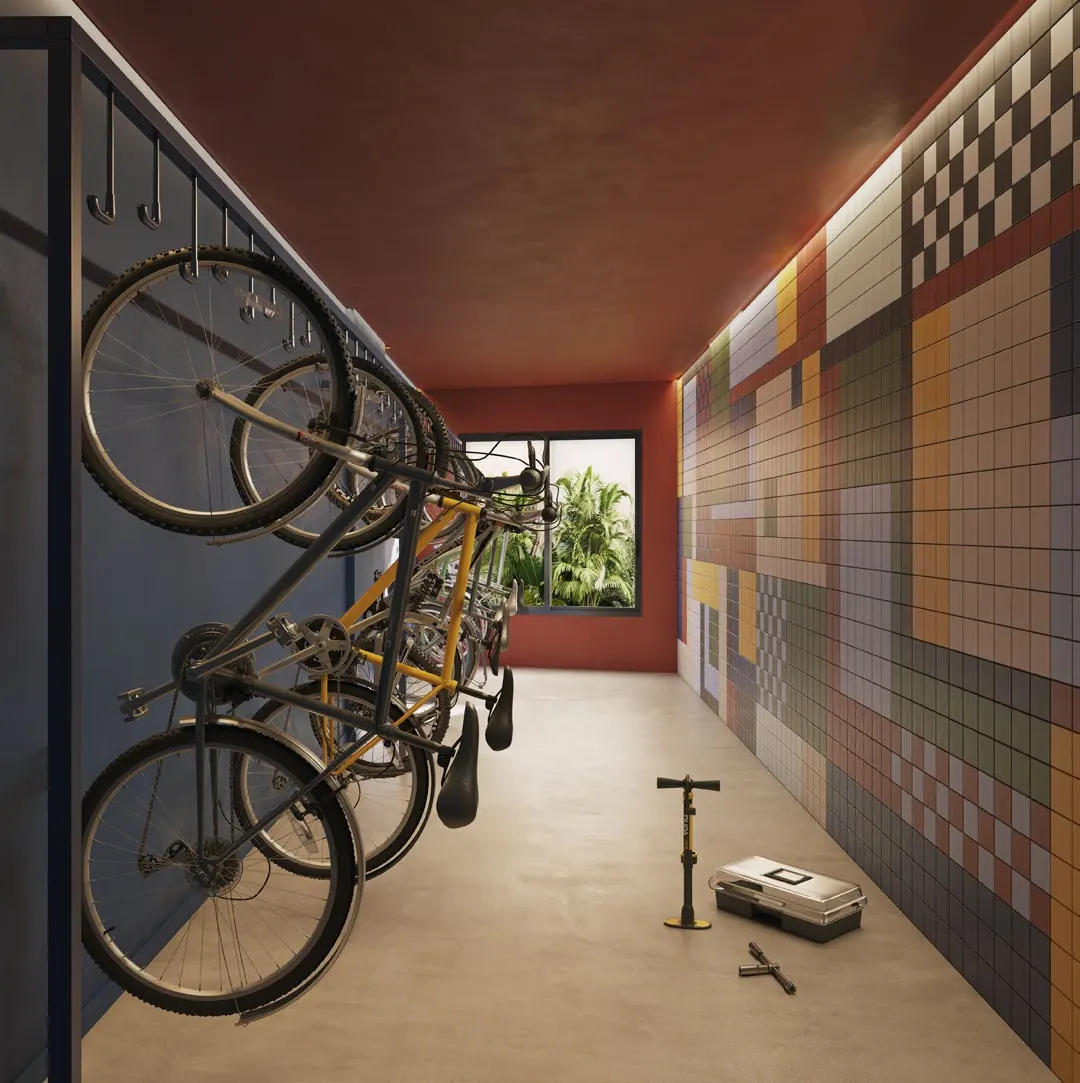 Bicicletário do Parque Studios com bicicletas penduradas e painel de azulejos coloridos