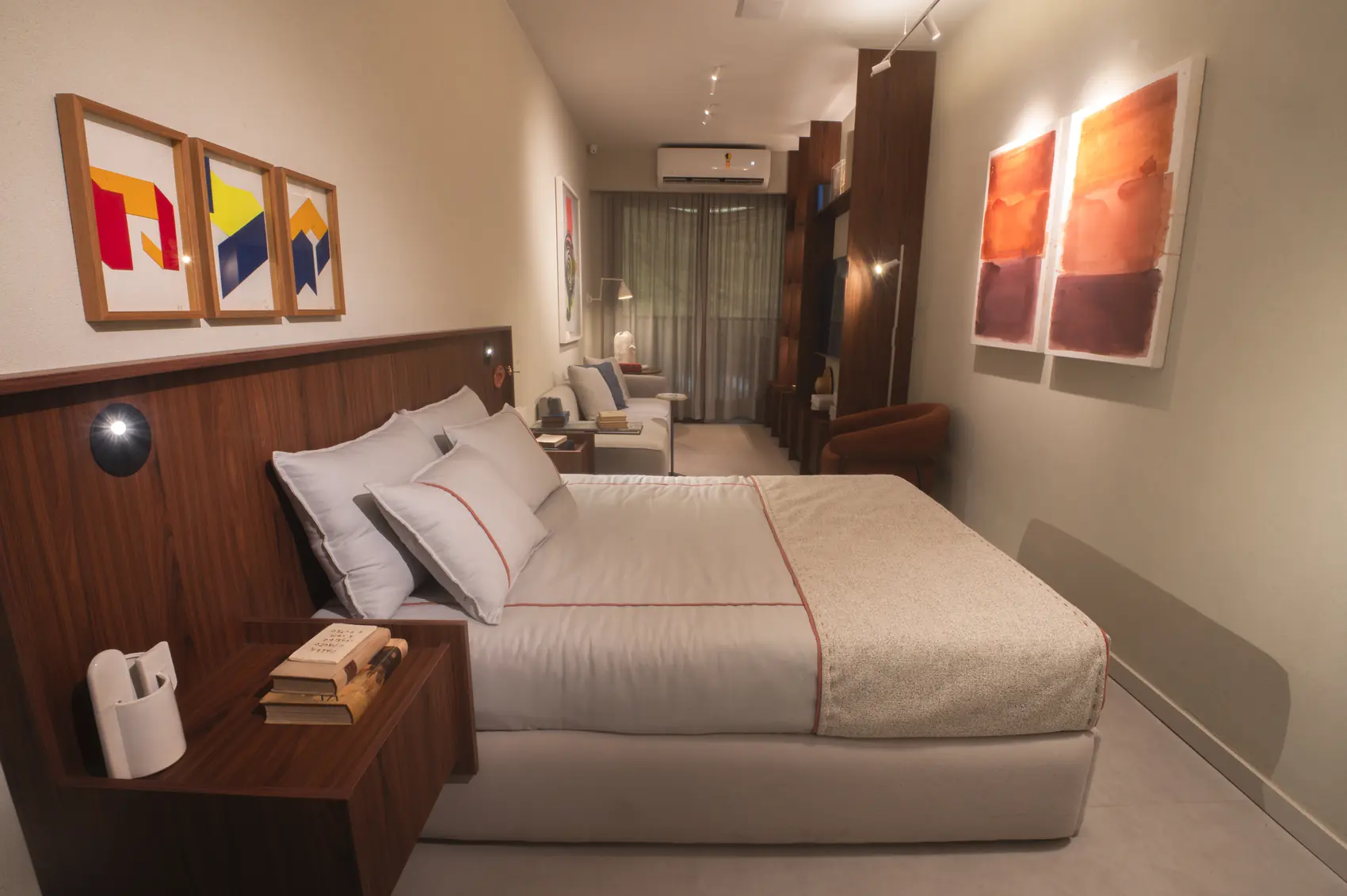 Studio decorado do Parque Studios com cama, marcenaria em madeira e obras de arte